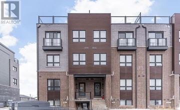 Niagara Falls (Morrison) townhouse for rent - A multi-story brick building with a balcony on the second floor.