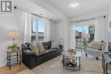 Niagara Falls (Morrison) townhouse for rent - A well-lit, modern living room with a black leather sofa and a glass coffee table.