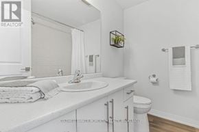 Niagara Falls (Morrison) townhouse for rent - A white bathroom with a sink, toilet, and a mirror.