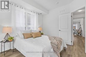 Niagara Falls (Morrison) townhouse for rent - A bedroom with a bed, two lamps, and a chair.