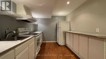 London North (North F) apartment for rent - A kitchen with white cabinets and a wooden floor.