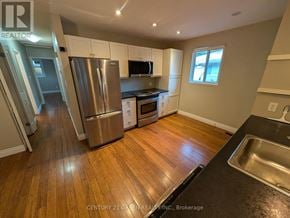 London North (North F) apartment for rent - A kitchen with wooden floors and stainless steel appliances.