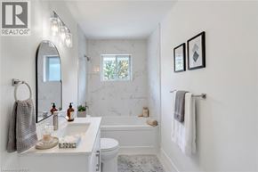 Brantford apartment for rent - A white bathroom with a marble wall and a towel rack.