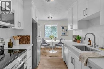 Brantford apartment for rent - A modern kitchen with white cabinets and a wooden floor.