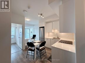 Toronto (Mount Pleasant West) condo for rent - A modern kitchen with white cabinets and a dining table with four chairs.