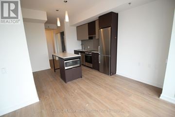 Toronto (Kensington-Chinatown) condo for rent - A kitchen with wooden floors and stainless steel appliances.