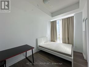 Toronto (Henry Farm) condo for rent - A bedroom with a bed, table, and window.