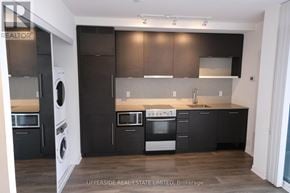 Toronto (Waterfront Communities) condo for rent - A modern kitchen with dark brown cabinets and stainless steel appliances.