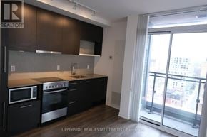 Toronto (Waterfront Communities) condo for rent - A kitchen with dark brown cabinets and stainless steel appliances.