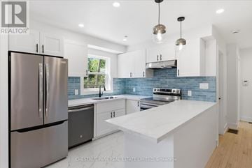 Toronto (Greenwood-Coxwell) townhouse for rent - A modern kitchen with a stainless steel refrigerator and a white countertop.