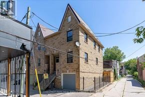 Toronto (Greenwood-Coxwell) townhouse for rent - A brick building with a sign that says Chestnut Park Real Estate.