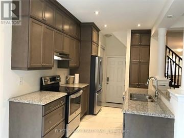 Richmond Hill apartment for rent - A kitchen with brown cabinets and a granite countertop.