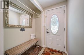 Georgina (Keswick North) apartment for rent - A white door with a glass window is in a room with a wooden bench and a mirror.
