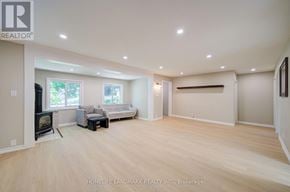 Georgina (Keswick North) apartment for rent - A spacious living room with wood flooring and a fireplace.