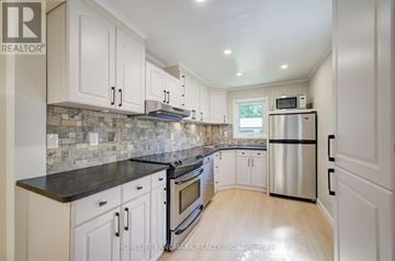Georgina (Keswick North) apartment for rent - A kitchen with white cabinets and a black countertop.