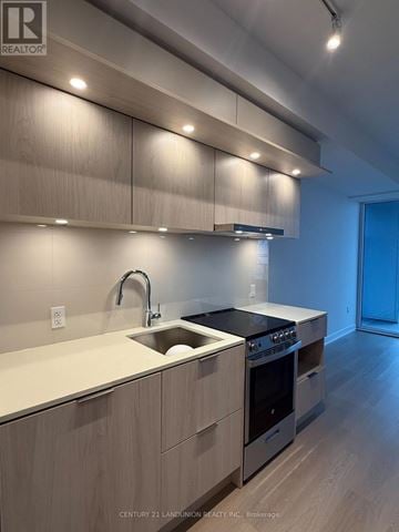 Mississauga (City Centre) condo for rent - A modern kitchen with wooden cabinets and stainless steel appliances.