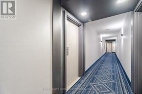 Mississauga (City Centre) condo for rent - A long hallway with a blue carpet and white walls.
