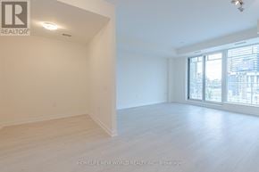 Toronto (Waterfront Communities) condo for rent - A large, empty room with a window overlooking a cityscape.
