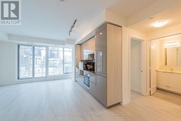 Toronto (Waterfront Communities) condo for rent - A spacious kitchen with wooden cabinets and a large window.