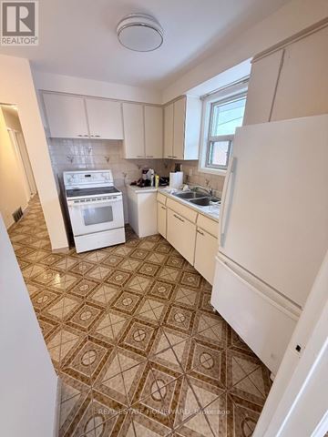 Toronto (Clairlea-Birchmount) apartment for rent - A kitchen with a tile floor and white appliances.