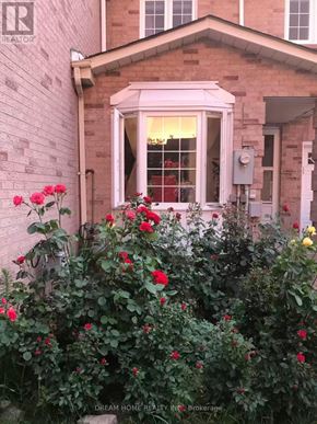 Mississauga (East Credit) townhouse for rent - A house with a window and flowers in front.