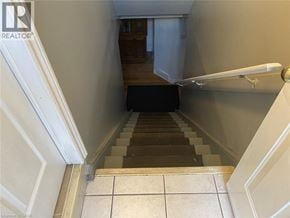 Welland apartment for rent - A staircase with a black carpet leading to a door.