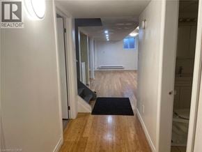 Welland apartment for rent - A hallway with a black doormat and wooden floors.
