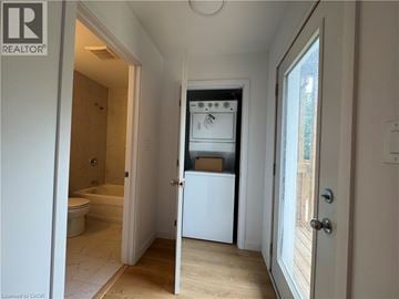 Welland townhouse for rent - A white refrigerator is in a kitchen with a door open.