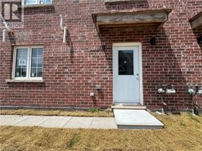 Welland townhouse for rent - A red brick house with a white door and a small window.