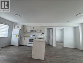 Welland townhouse for rent - A well-lit kitchen with a refrigerator, oven, and sink.
