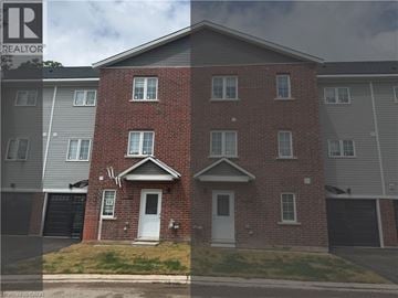 Welland townhouse for rent - A red brick house with a white door and windows.