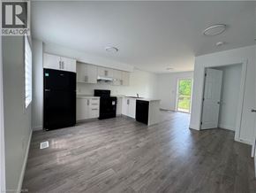 Welland townhouse for rent - A well-lit, spacious kitchen and living room with wood flooring and white walls.