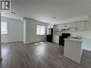 Welland townhouse for rent - A spacious kitchen with a sink, stove, and cabinets.