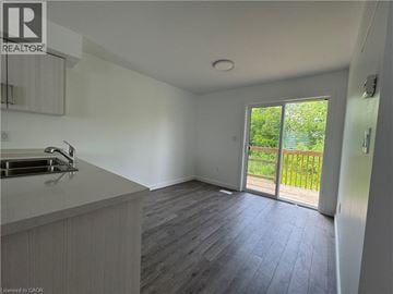 Welland townhouse for rent - A kitchen with a sink and a window overlooking a green area.