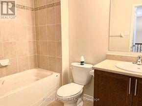 Ottawa townhouse for rent - A bathroom with a toilet, sink, and bathtub.
