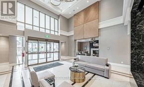 Niagara Falls (Hospital) condo for rent - A spacious living room with a grey sofa and a coffee table.