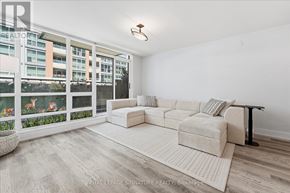 Toronto (Waterfront Communities) condo for rent - A living room with a white couch and a fish tank.