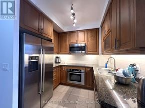 Toronto (Bay Street Corridor) condo for rent - A kitchen with wooden cabinets and stainless steel appliances.