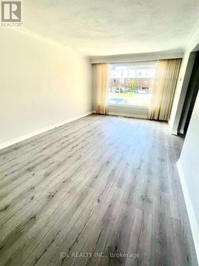Toronto (Agincourt South-Malvern West) apartment for rent - A room with wooden flooring and a window with curtains.