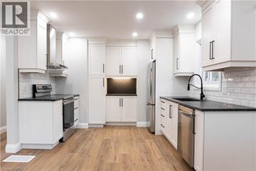 Kitchener apartment for rent - A modern kitchen with white cabinets and a black countertop.