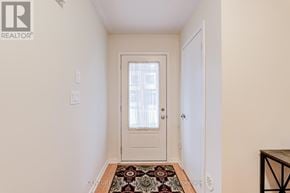Oshawa (Eastdale) townhouse for rent - A hallway with a rug on the floor and a door at the end.