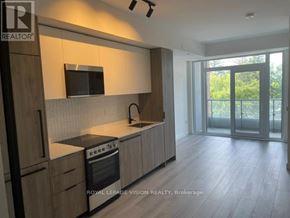 Toronto (Centennial Scarborough) condo for rent - A modern kitchen with wooden cabinets and a black stove top oven.