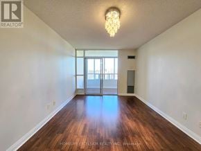 Markham (Milliken Mills East) condo for rent - A large, empty room with wood flooring and a chandelier.
