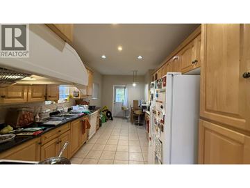 Burnaby apartment for rent - A kitchen with wooden cabinets and a white refrigerator.