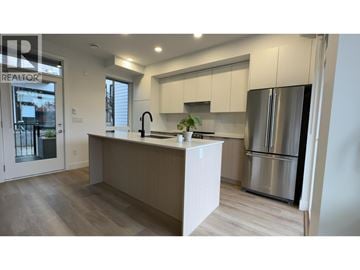 Coquitlam townhouse for rent - A modern kitchen with a large island and stainless steel appliances.