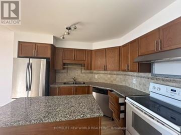 Richmond Hill (Harding) condo for rent - A kitchen with wooden cabinets and granite countertops.