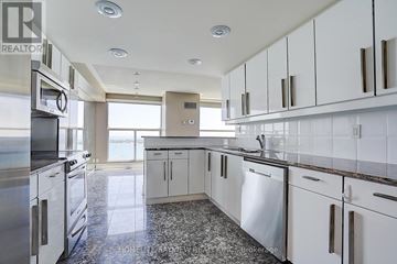 Toronto (Waterfront Communities) condo for rent - A modern kitchen with white cabinets and a marble floor.