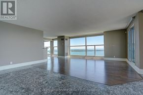 Toronto (Waterfront Communities) condo for rent - A spacious room with a view of the beach through large windows.