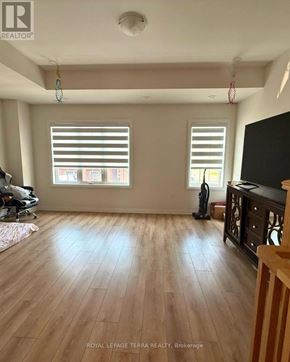 Oshawa (Windfields) townhouse for rent - A room with wooden floors and two windows with blinds.