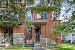 Ottawa townhouse for rent - A brick building with a tree in front.